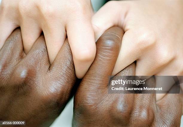 couples' hands connected - black and white hands fotografías e imágenes de stock