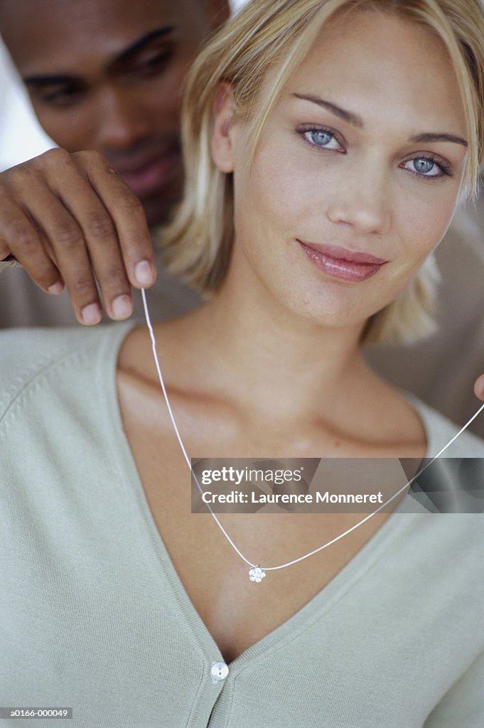 Man Placing Necklace on Woman