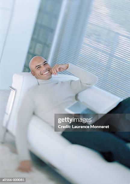 man lying on sofa with laptop - high collar ストックフォトと画像