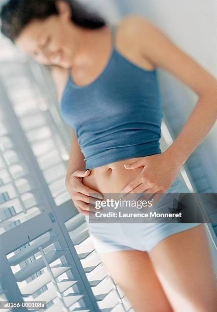 woman looking at her stomach - tanga stock-fotos und bilder