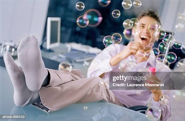 businessman blowing bubbles - perder el tiempo fotografías e imágenes de stock