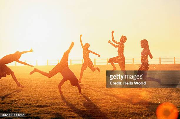 children playing in sprinkler - jumping sun bildbanksfoton och bilder