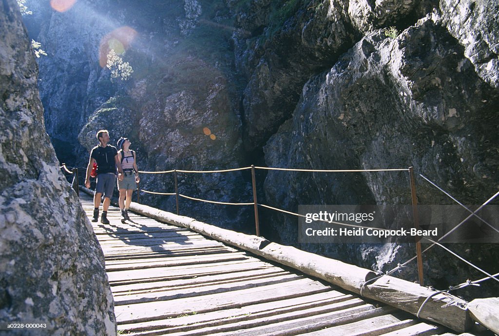 Hikers Walking over Bridge