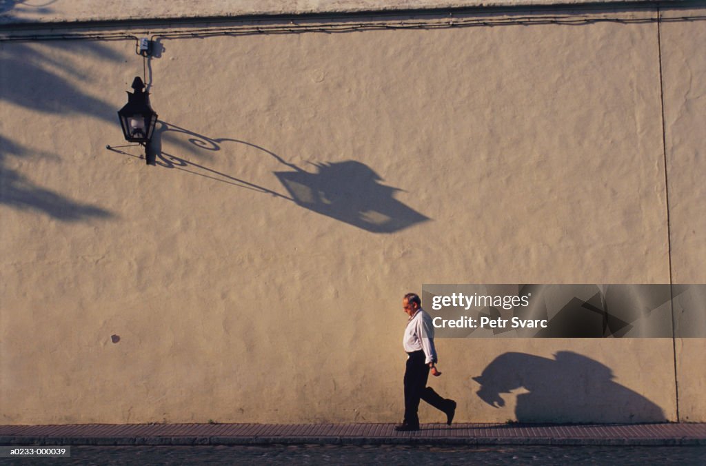 Man Walking by Wall