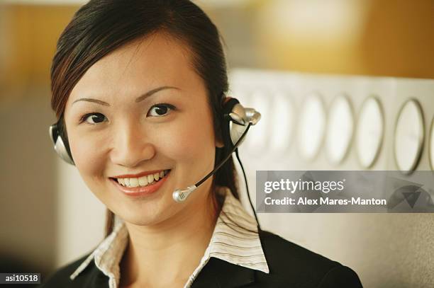 young woman wearing hands-free device, looking at camera - duty free 個照片及圖片檔