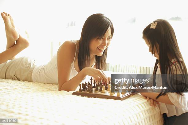 mother and daughter playing chess in bedroom - girl soles stock pictures, royalty-free photos & images