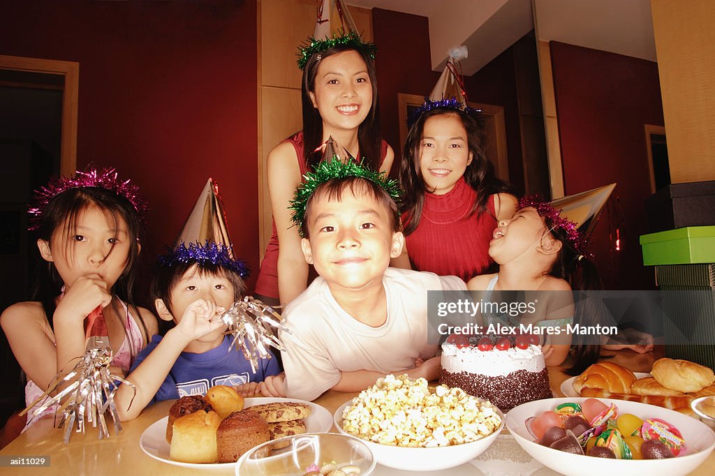 Young boy at a birthday party, surrounded by friends