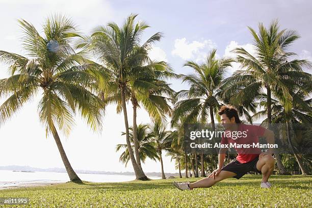 man doing stretching exercises in park, hand on knee - hand on knee ストックフォトと画像