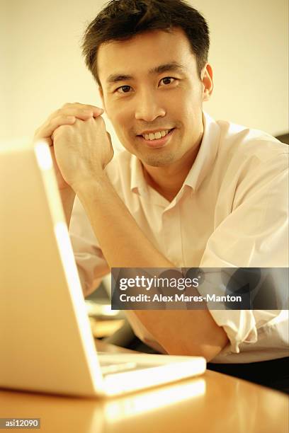 executive sitting with elbows on desk, hands clasped, looking at camera - hinge joint stock pictures, royalty-free photos & images