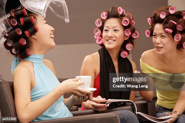 young women at beauty salon, drinking tea and talking - beauty salon foto e immagini stock