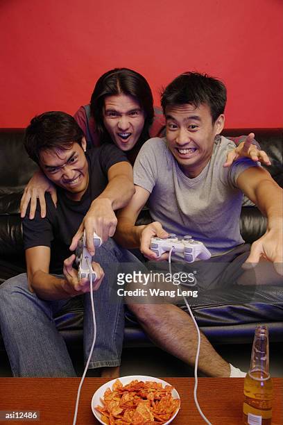 young men at home playing with video games - avond thuis stockfoto's en -beelden