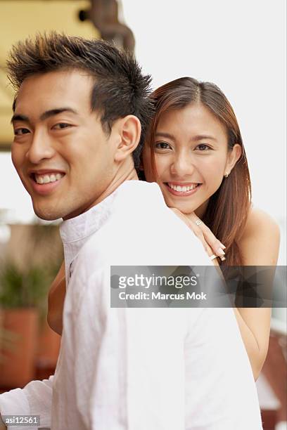 young man in profile, young woman in front of him, smiling - marcas stock-fotos und bilder