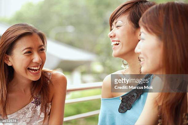 three young women, smiling - marcas stock-fotos und bilder