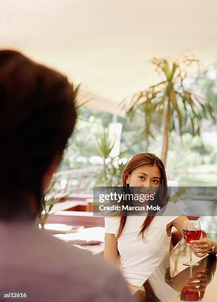 woman with wine glass, looking at man. - marcas stock-fotos und bilder