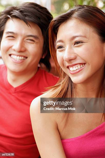 couple sitting side by side, toothy smiles - marcas stock-fotos und bilder