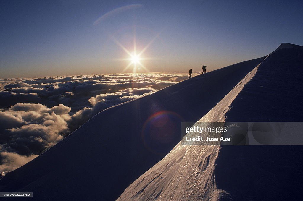 Two mountaineers silhouetted by the setting sun, New Zealand.