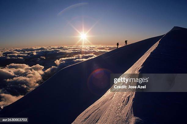 two mountaineers silhouetted by the setting sun, new zealand. - summit day 2 stock pictures, royalty-free photos & images