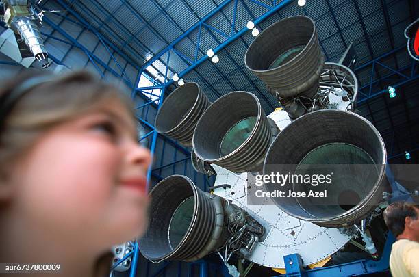 girl next to rocket engines, cape canaveral, kennedy space center, florida, usa. - nasa kennedy space center stockfoto's en -beelden