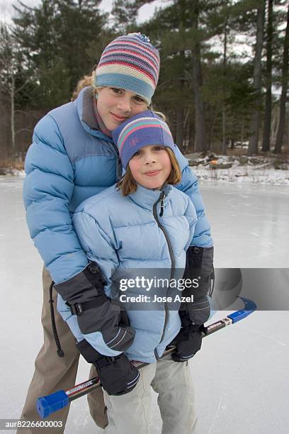 two girls looking at camera while standing on frozen pond, new england, usa - new england   usa stock pictures, royalty-free photos & images