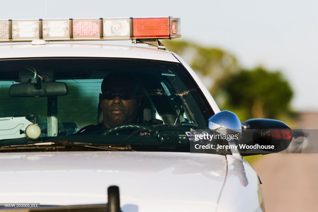 Police officer sitting in a police car