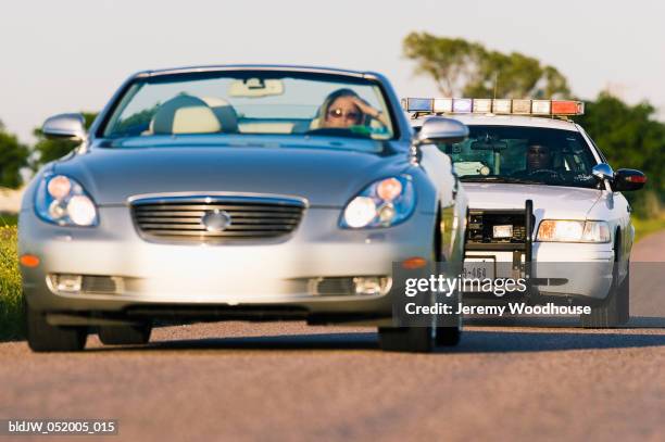 police car chasing a convertible car - verfolgen stock-fotos und bilder