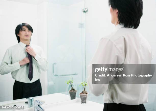 businessman adjusting his tie in a mirror, beijing, china - bassine photos et images de collection