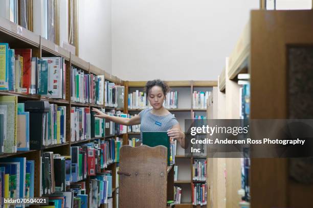 Library Tutorial On Arranging Books 29 Young Female Librarian Arranging Books On Library Shelves Stock ...