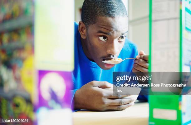 teen boy enjoying cereal - boy eating cereal stock pictures, royalty-free photos & images
