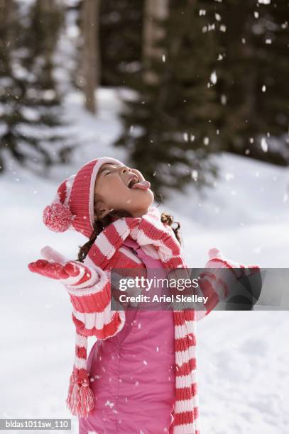 side profile of a girl sticking out her tongue to catch snowflakes - tong uitsteken stockfoto's en -beelden