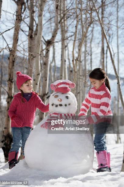 two girls making a snowman - children only braided ponytail stock pictures, royalty-free photos & images