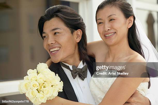 young couple in their wedding outfits - ariel skelley stock-fotos und bilder