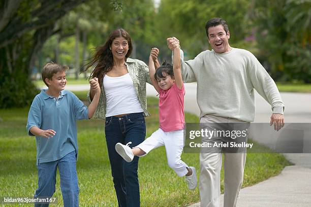 portrait of a family walking in the park - ariel skelley stock pictures, royalty-free photos & images