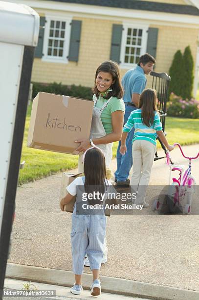 young couple and their children standing in front of a house - ariel skelley stock-fotos und bilder