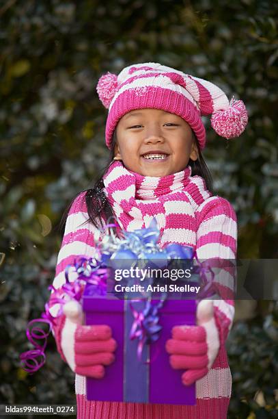 portrait of a girl holding a gift - ariel skelley stock pictures, royalty-free photos & images