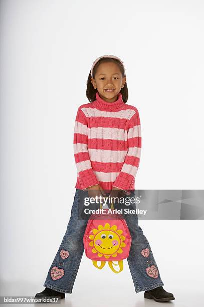 portrait of a girl holding a schoolbag - ariel skelley stock-fotos und bilder