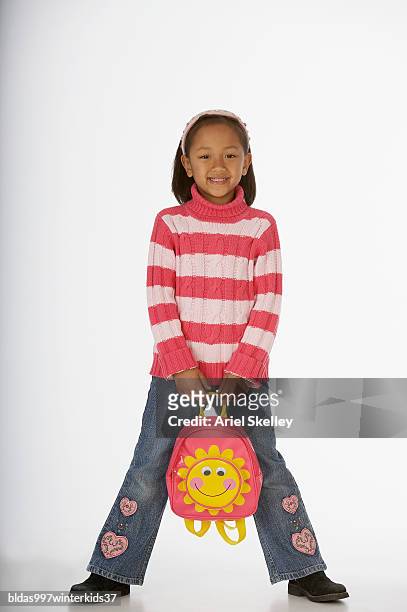 portrait of a girl holding a schoolbag - ariel skelley stock pictures, royalty-free photos & images