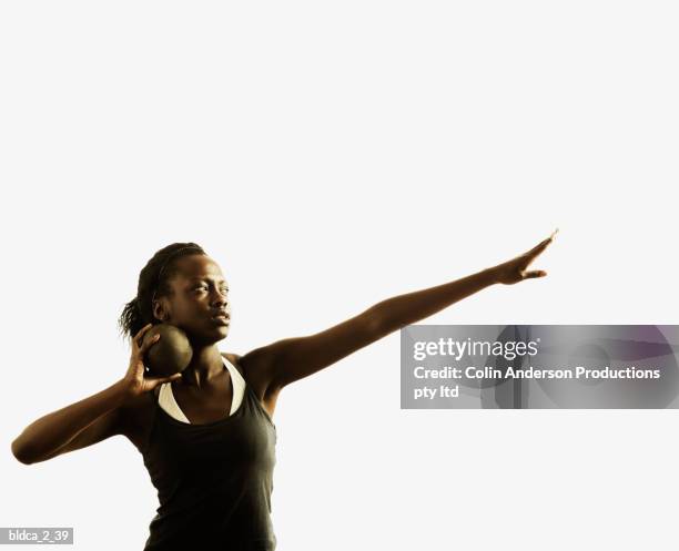 young woman holding a shot put ball - womens field event stockfoto's en -beelden