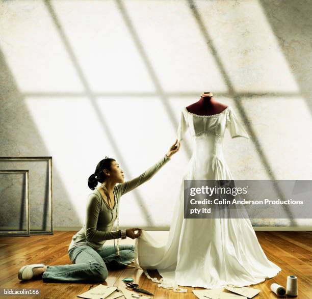 young seamstress working on a wedding gown on a mannequin - mannequin legs stock pictures, royalty-free photos & images