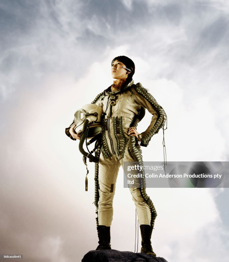 Young female astronaut holding a space helmet