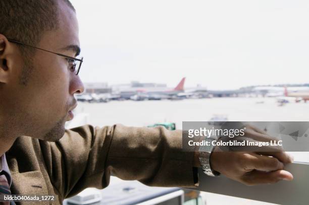 side profile of a young businessman looking at his wristwatch - travel12 stock pictures, royalty-free photos & images