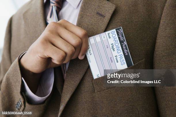 close-up of a businessman's hand removing a boarding pass from a jacket pocket - hands in pockets foto e immagini stock