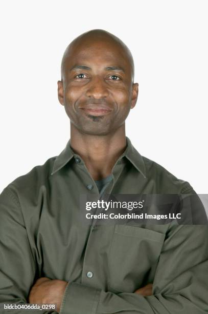 portrait of a young man standing with arms folded looking at camera - black shirt folded stock pictures, royalty-free photos & images