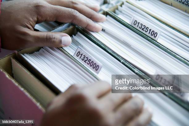 person searching through files in a file drawer - searching for something �ストックフォトと画像