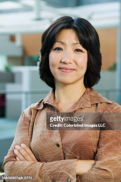 portrait of a businesswoman standing with her arms folded looking at camera smiling - folded blouse stock pictures, royalty-free photos & images