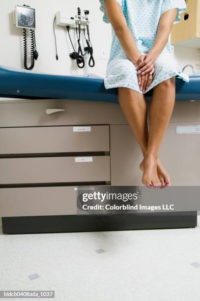 view of a patient's legs dangling from a bed - examination gown stock pictures, royalty-free photos & images