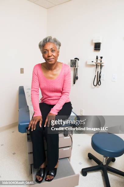 portrait of a mature adult female patient sitting on an examination table - tavolo da visita foto e immagini stock