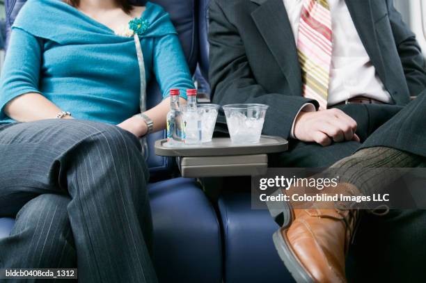 adult couple traveling in an airplane - mid section fotografías e imágenes de stock