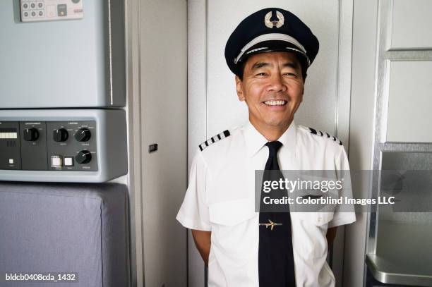 portrait of mid adult male pilot smiling - aviatrice stock-fotos und bilder