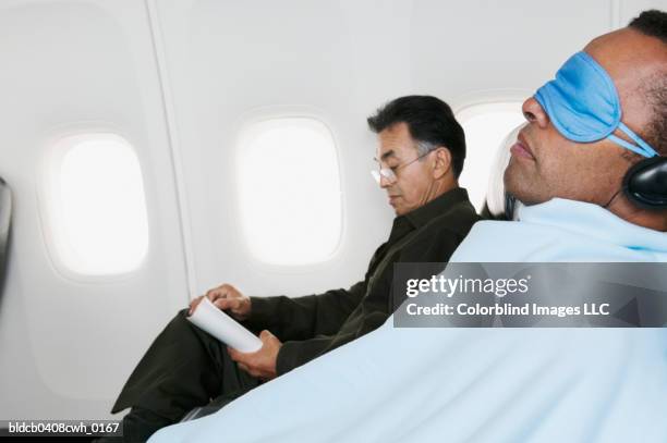 mid adult man traveling in an airplane - travel11 stock pictures, royalty-free photos & images
