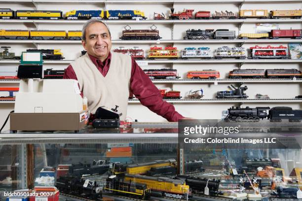 portrait of a male sales clerk standing in a toy store - toy store stock pictures, royalty-free photos & images